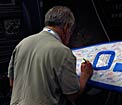 Attendee signing the IAU surfboard